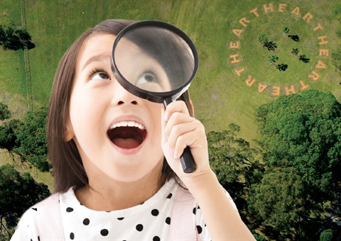 Girl with magnifying class looking at MAC yapang Sculpture Park using the Family Activity Guide
